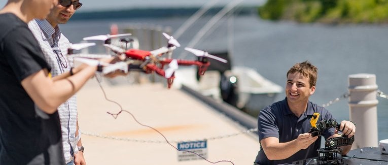 Researchers testing a drone and other equipment outside.