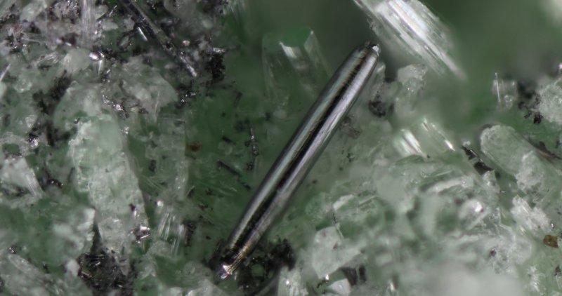 image of a geological sample that includes a whisker of merelaniite.