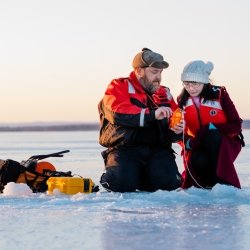 Researchers doing research on an ice covered lake.