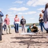 A group of people stand on a beach.