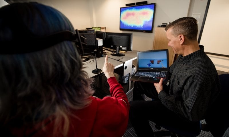 Keith Vertanen observing student testing the VR keyboard.