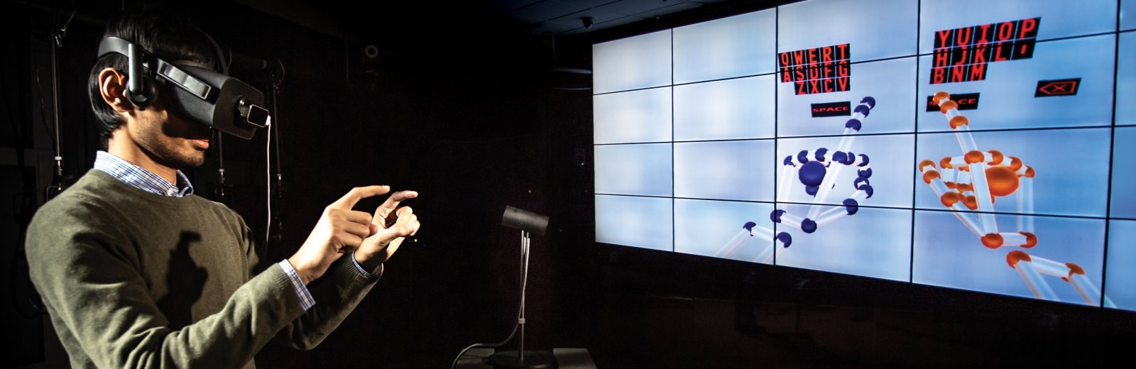 Person wearing VR goggles interacting with virtual keyboard.