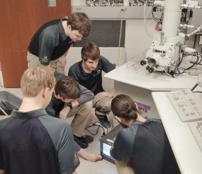 Five students working on equipment in a lab.