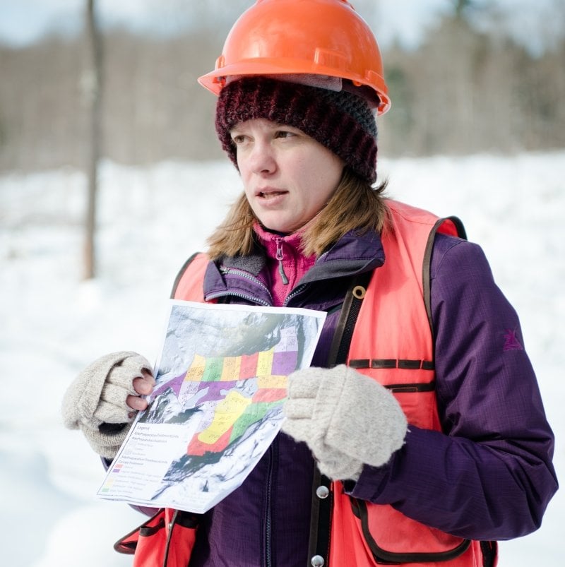 Researcher outside holding a map.