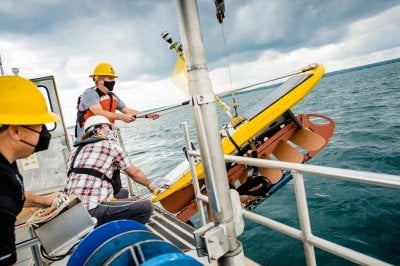 Crew aboard a boat release the glider into the water.