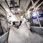 Researchers in protective gear testing the rover in the lunar dust.