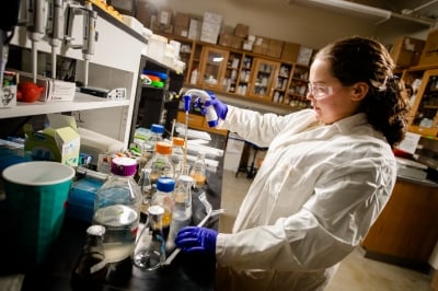 Woman working with liquids in a lab.