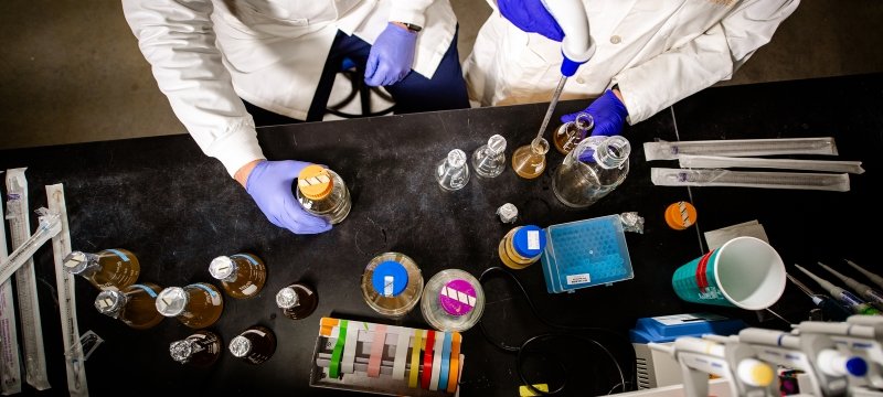 Overhead view of bottles and beakers on a lab table.