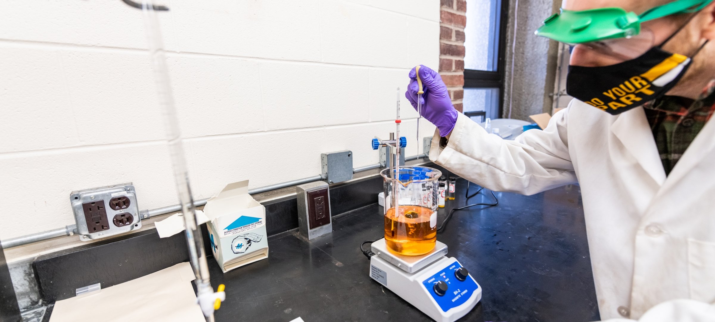 Researcher testing a liquid in a beaker on a scale inside a lab