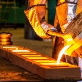 Pouring molten metal into sand mold