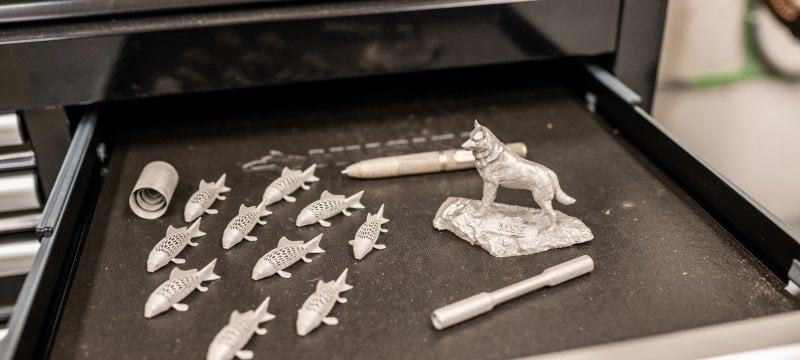 Metal 3-D printed items including fish and a Husky Statue.