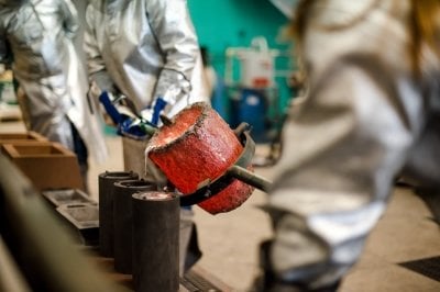 pouring liquid metal into cast