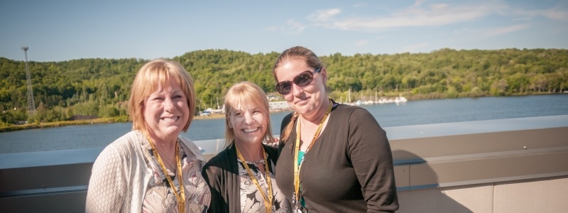 Alumni smiling with the Keweenaw Peninsula in the background