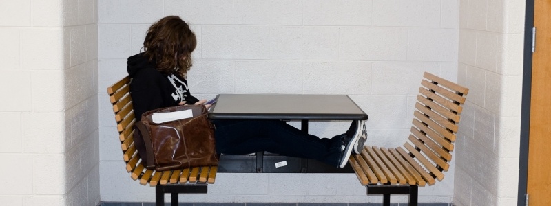 Student sitting at a bench table in Fisher Hall