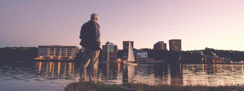 Faculty member standing across the water from Tech's campus at dusk