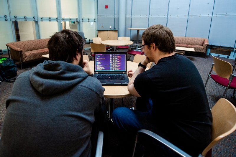 Two students working at a laptop.