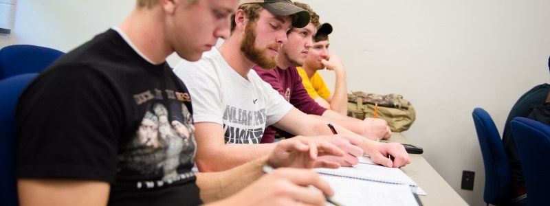 Students taking notes in a Mathematics course