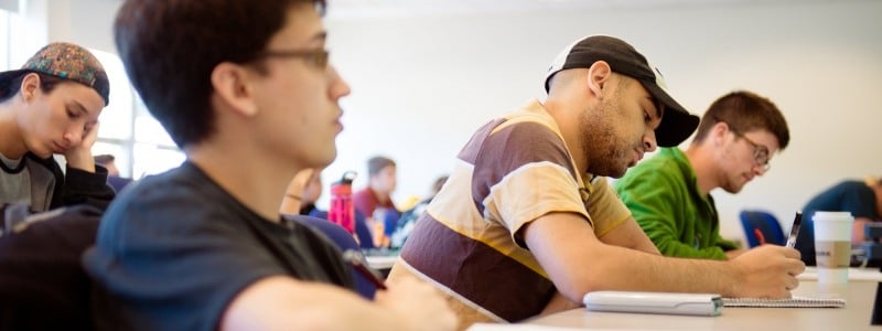 Student taking notes in Mathematics course