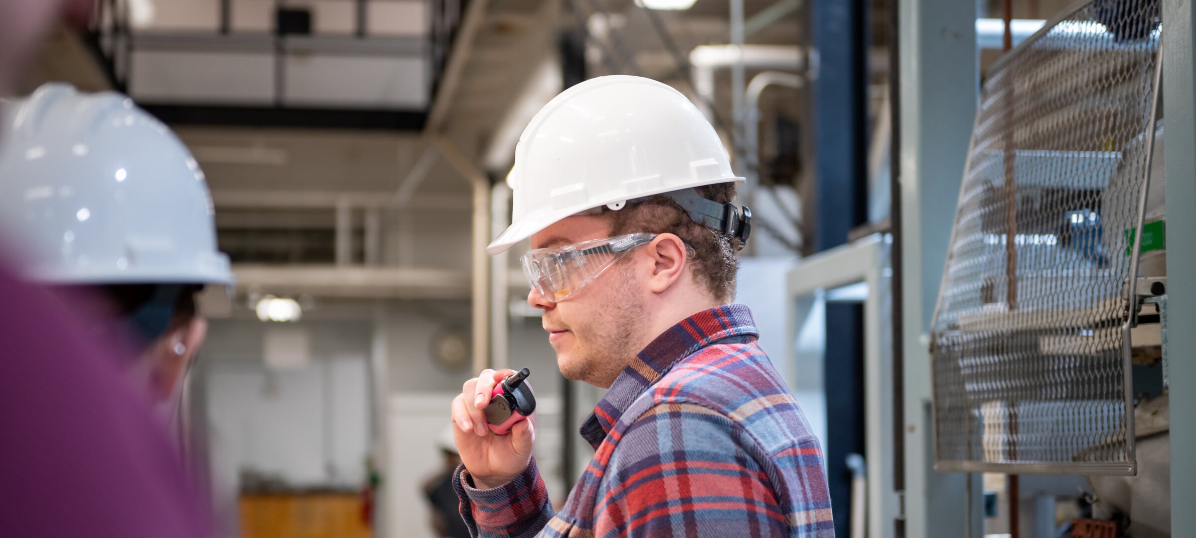 Someone wearing a hard hat and safety glasses