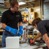 Two people working on a copper wire