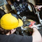A person using a drill on a machine