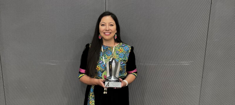 Aurora White holding an award.