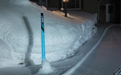 All UP Snowblowing sign on a driveway edge marker.