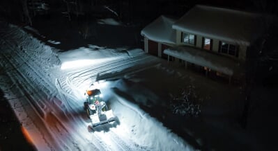 The snowblower heading to a driveway to clear snow.