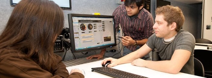 Three students working at a computer