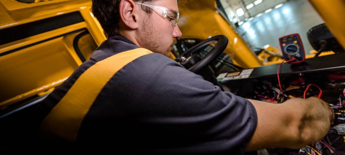 Graduate Student working inside the console of a piece of Pettibone equipment