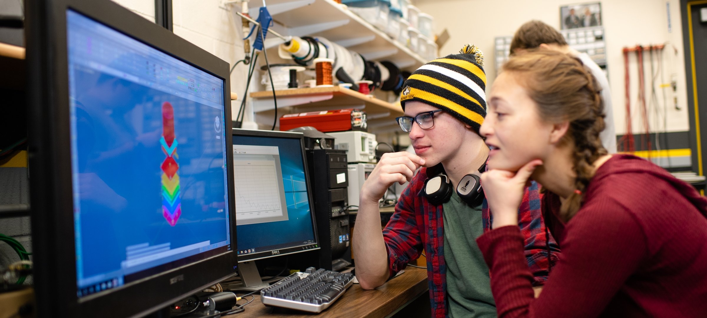 Two students looking at a model on a computer screen.