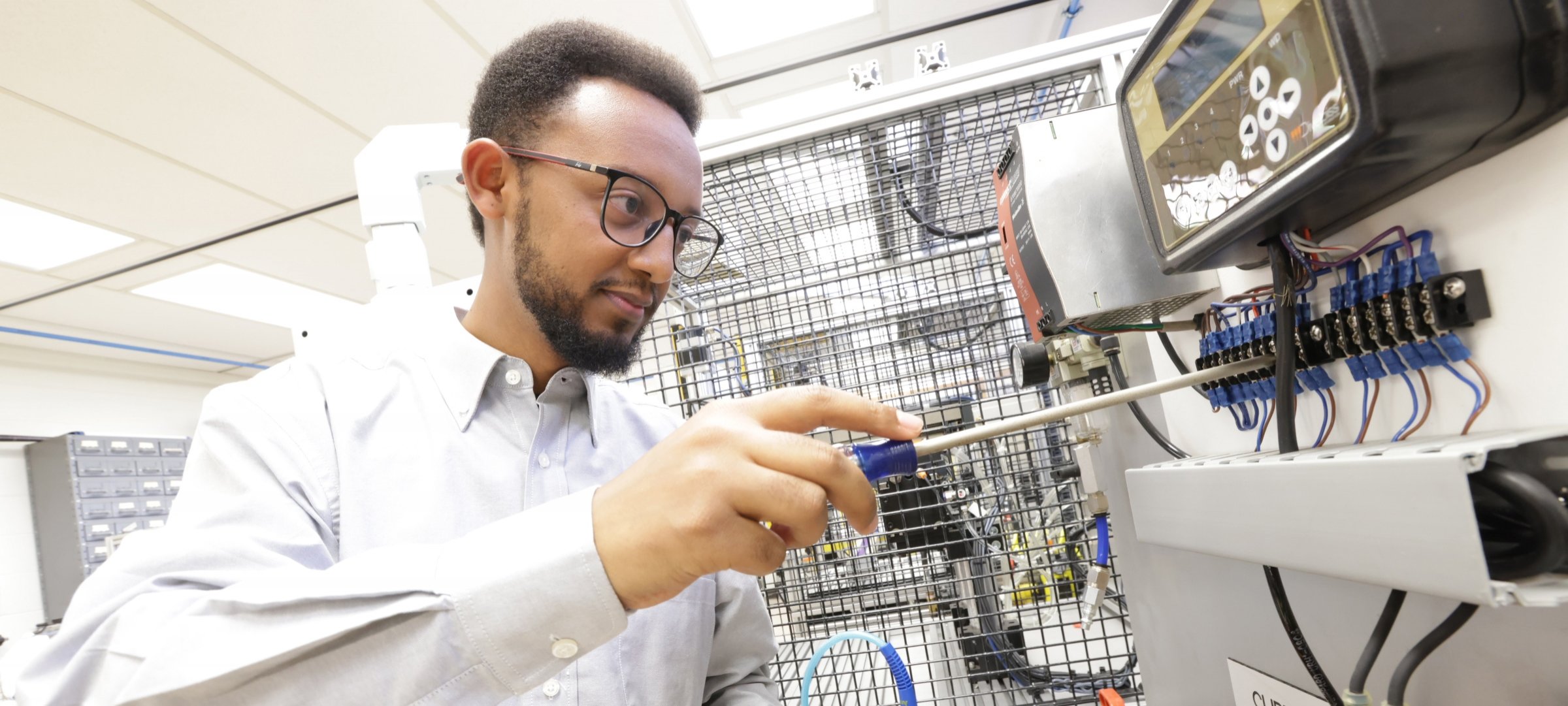 A Michigan Tech student operates industry-standard mechatronics equipment