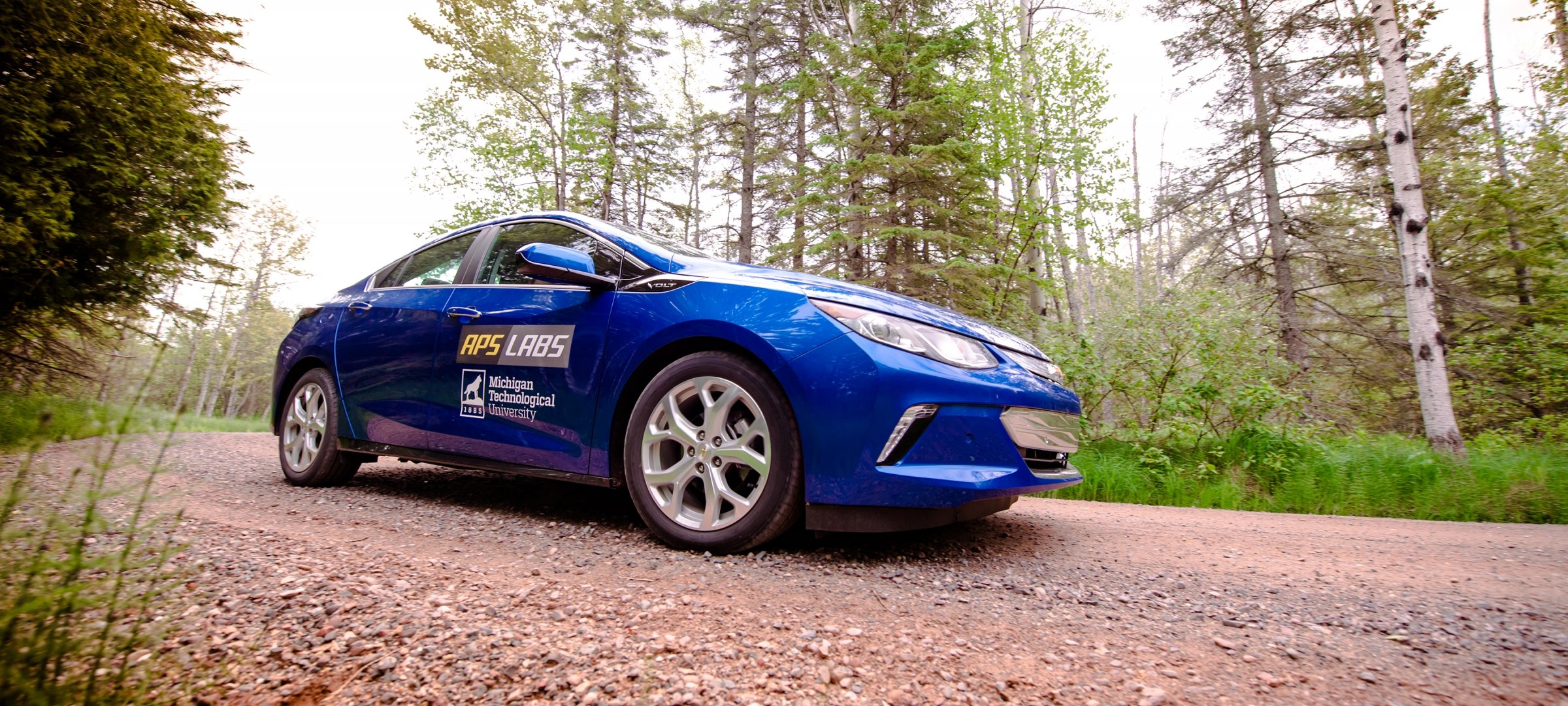 Blue electric vehicle on gravel road