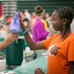 Student high fiving a blown up rubber glove.