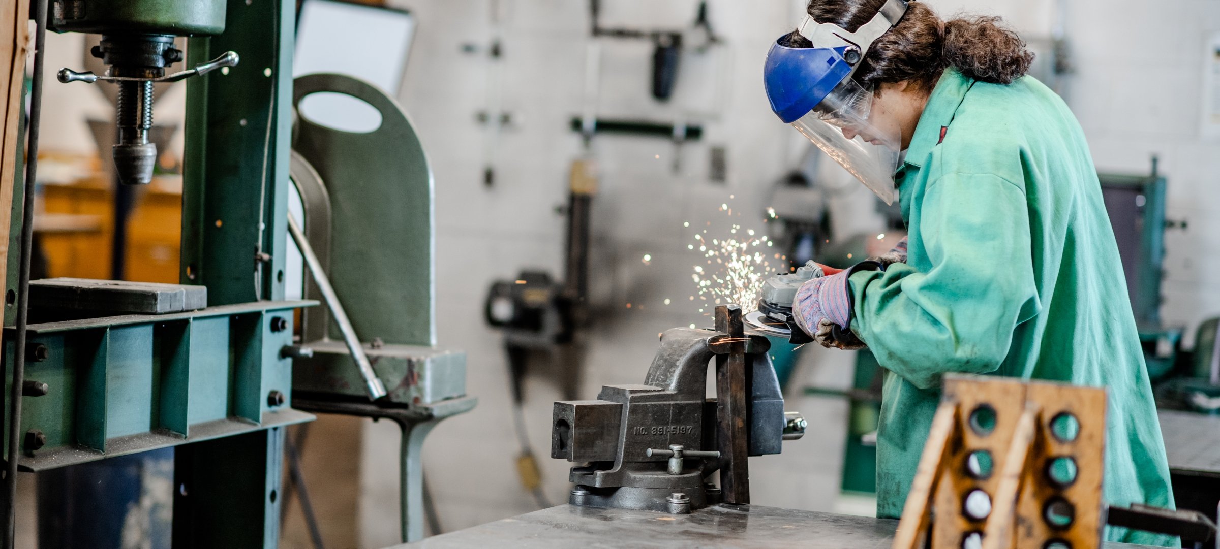 Mechanical Engineering Technology students get hands-on experience while cutting metal in protective gear.