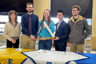 Group of students and presenter at an induction ceremony.