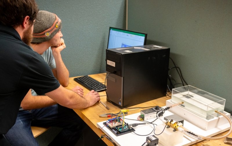Student at the computer with the sentry flow meter apparatus nearby.