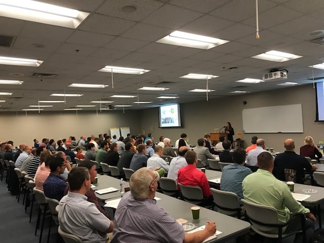 People at tables listening to a presentation.