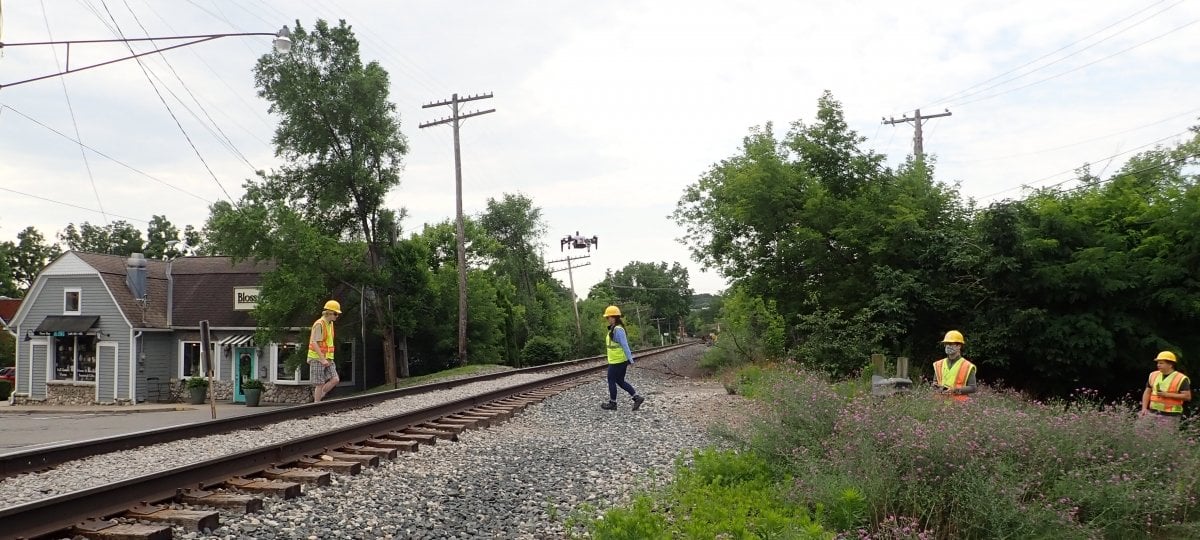 Group of people with a drone on a railroad