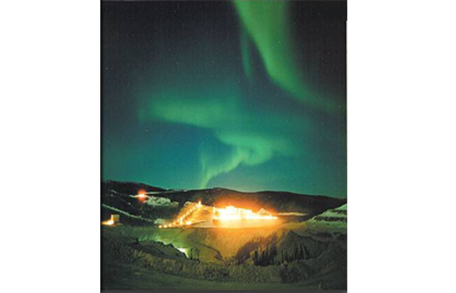 Lighted area beneath aurora borealis.
