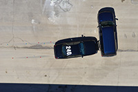 Overhead view of two cars on a road.