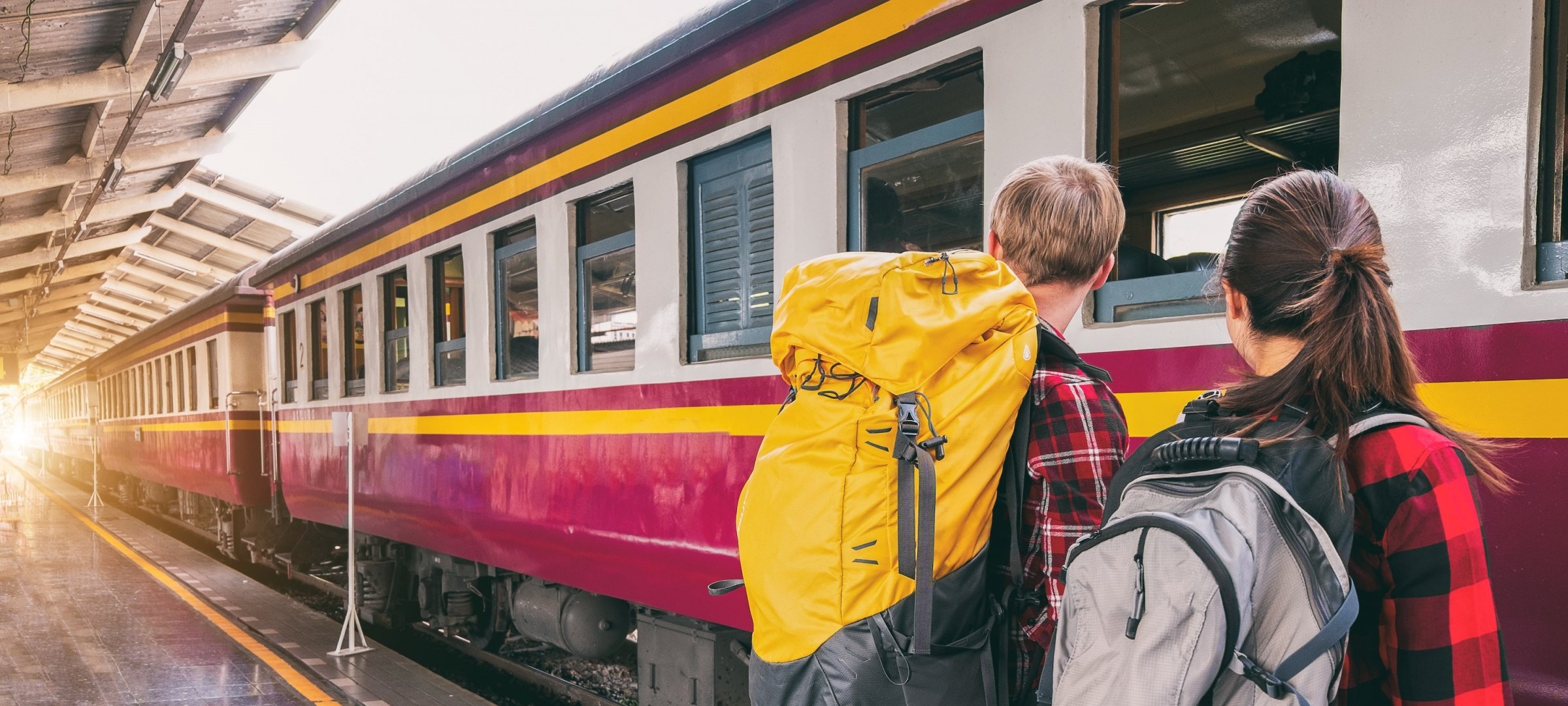 Students with back packs boarding a train.