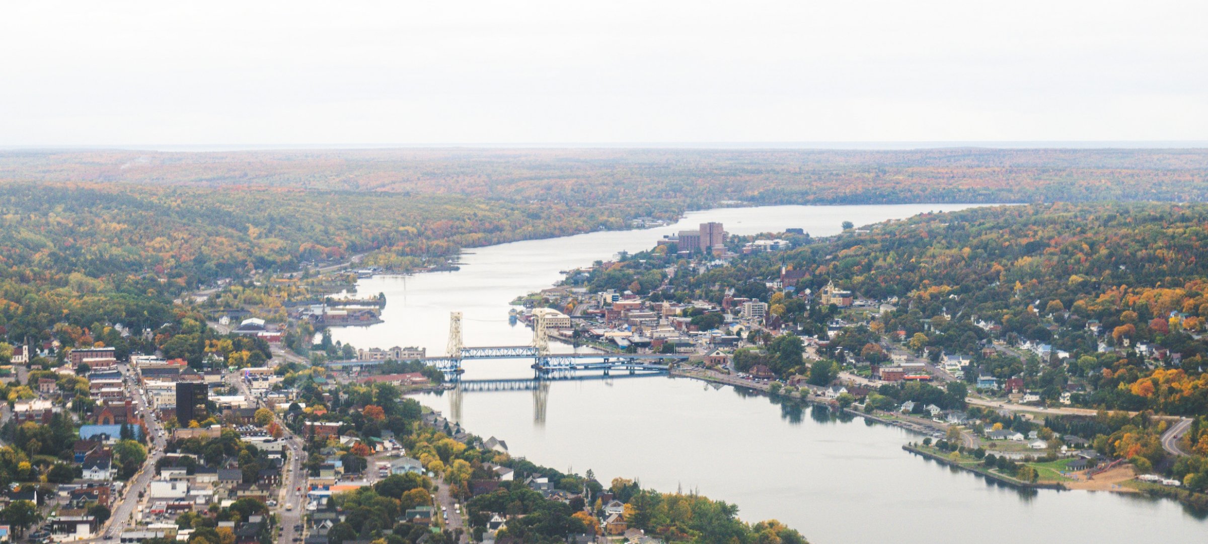 Aerial view of the Keweenaw waterway with Portage Lift Bridge and Michigan Tech in the distance.