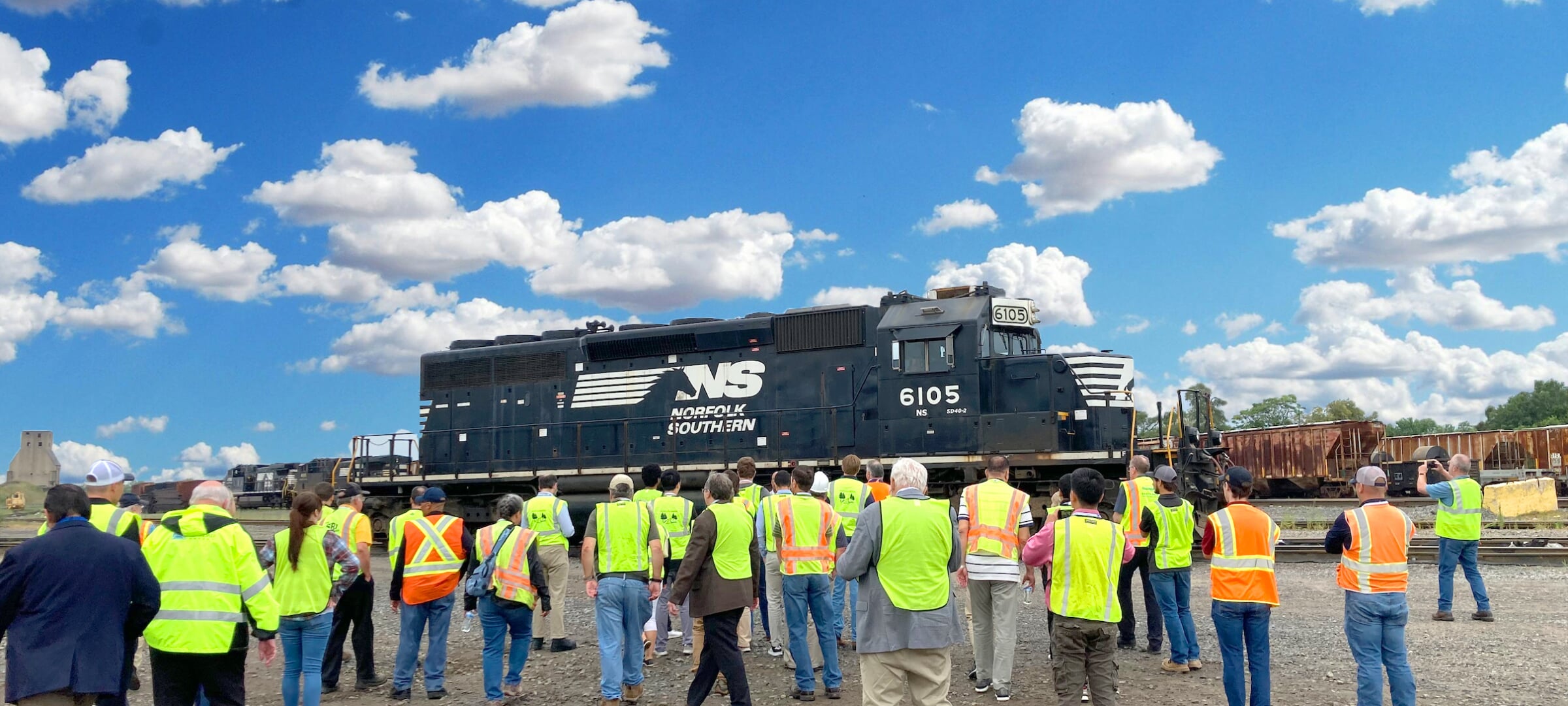 Train engine with people in vests walking up to view.
