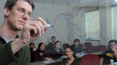 A professor writing on a board