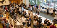A crowd of students and guests looking at their projects throng around tables at the Design Expo 2023, where undergraduate projects are on display for the public and judges each year as part of Michigan Tech's commitment to hands-on learning.