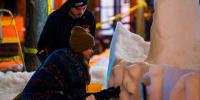 Two students working on adding details to a snow statue during all-nighter.