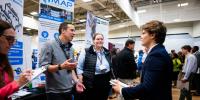 Student talking to recruiters from Michigan Air Products at their booth.