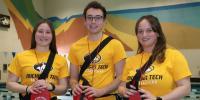 Three lifeguards at the Michigan Tech student development complex pool smile in a photo celebrating their lifesaving award.