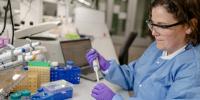 A research scientist for Michigan Techâ€™s Genomic Sequencing Lab works with equipment in the facility.